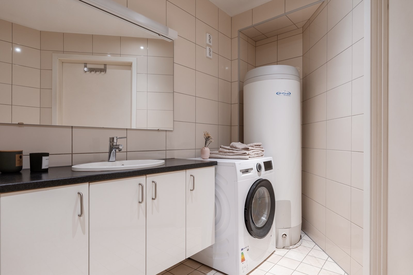 I 1. etasje ligger et romslig bad kombinert med vaskerom, med dusjløsning med glassdører, vegghengt toalett og baderomsinnredning med servant og god oppbevaringsplass. Galleribilde