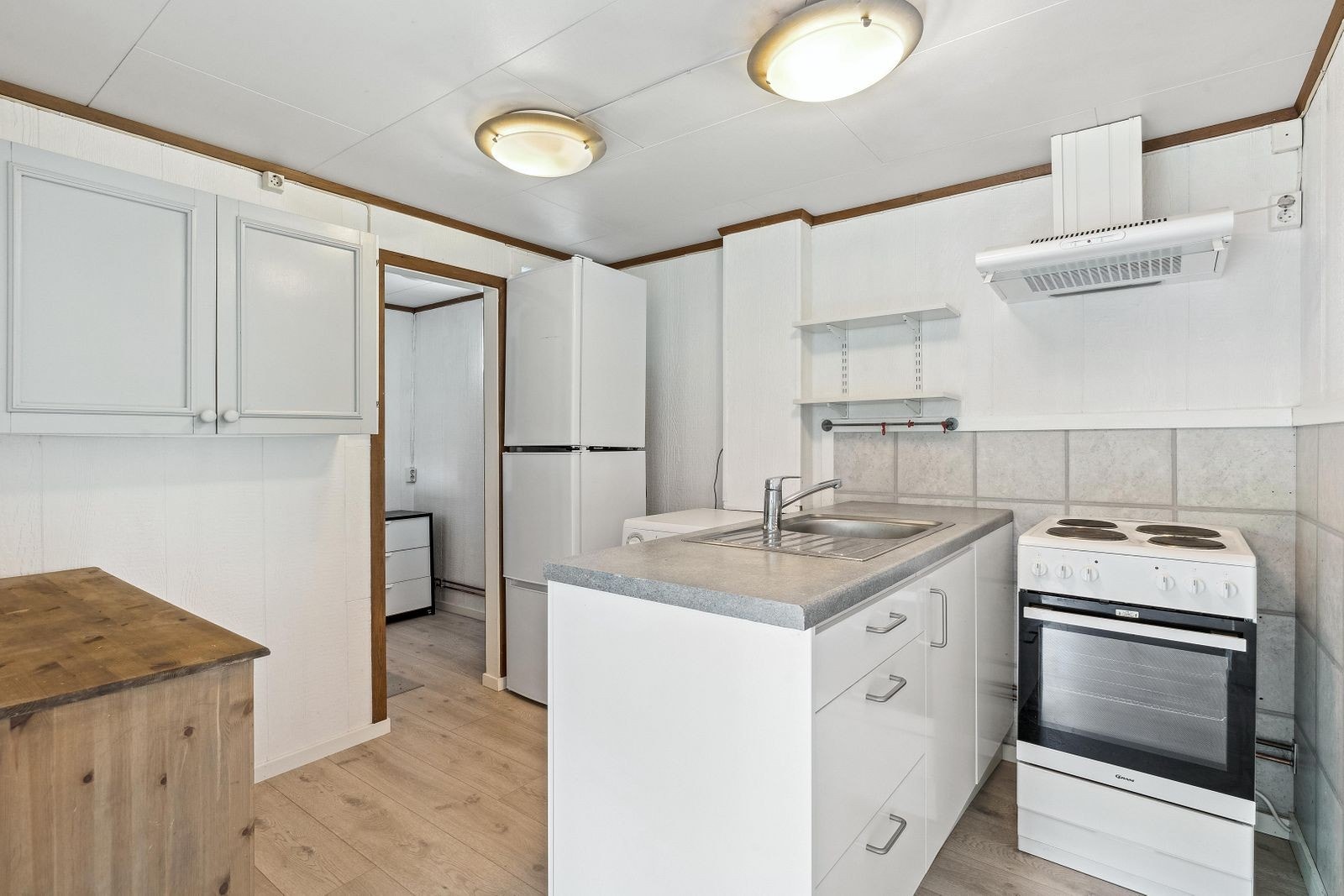 Hyggelig kjøkken utstyrt med komfyr, kombiskap, fryser og vaskemaskin. Galleribilde