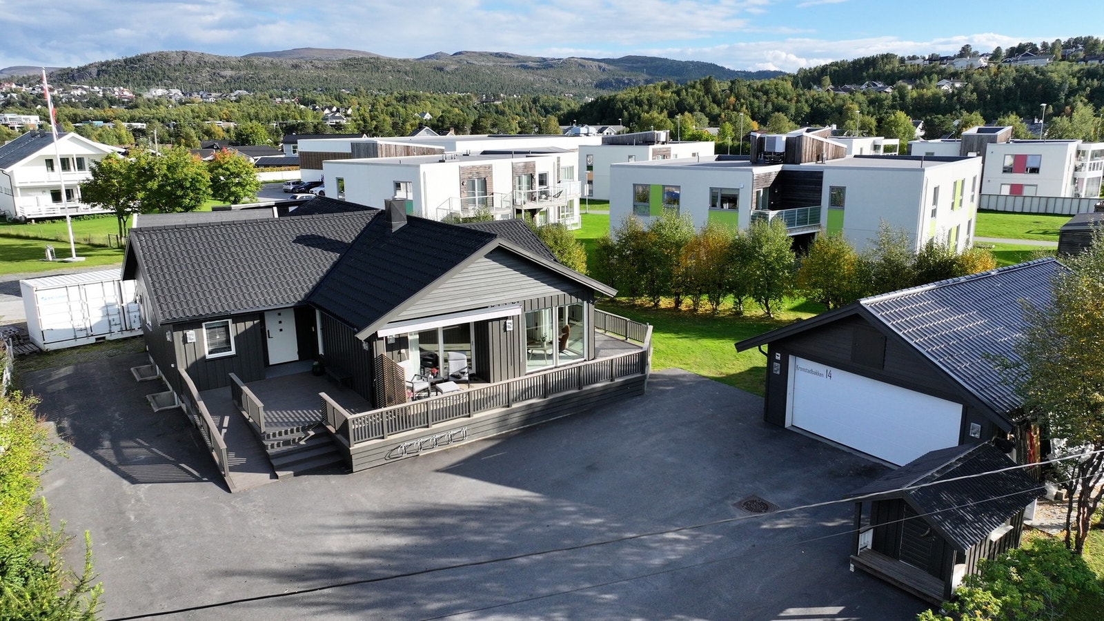 Asfaltert parkering med god plass til biler både ute og i garasje Galleribilde