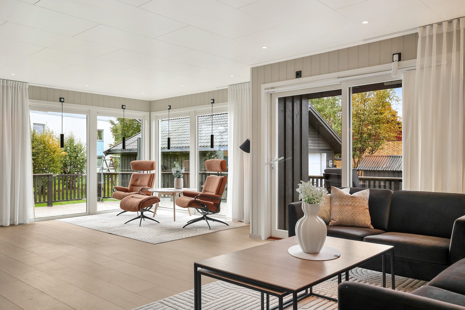 Romslig stue med god plass til flere sittegrupper Galleribilde