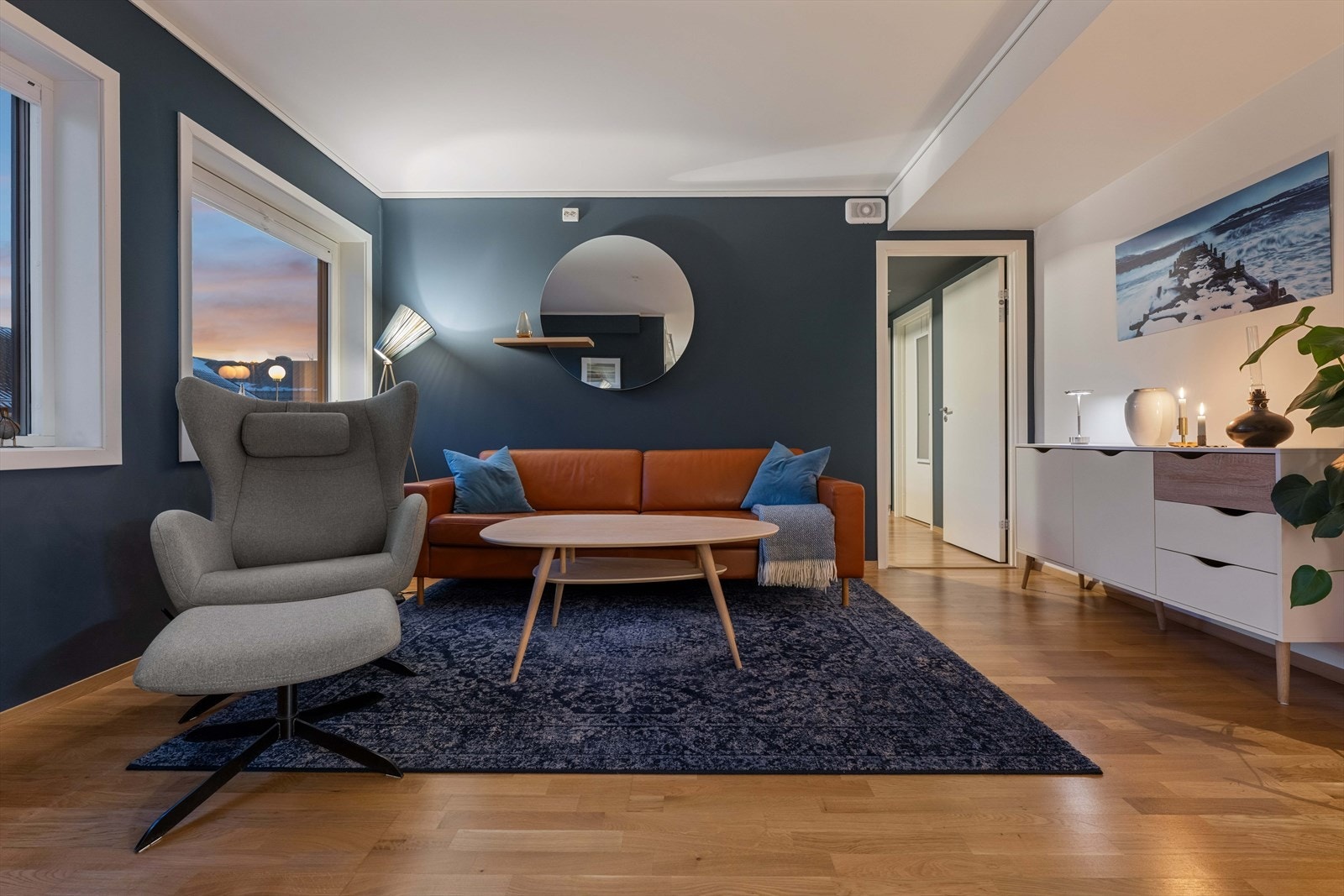 Stuen er utført med et stilrent parkettgulv og slette veggflater - De mørkeblå kontrastveggene skaper en lun og dempet atmosfære Galleribilde