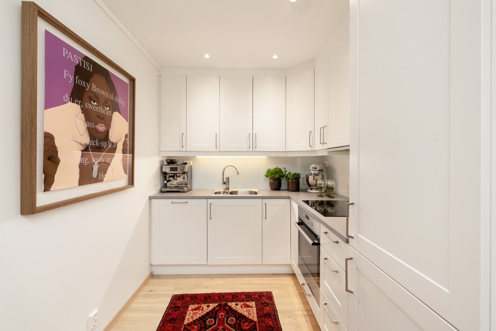 Kjøkken med komfyr, steketopp, oppvaskmaskin og kjøl/frys Galleribilde