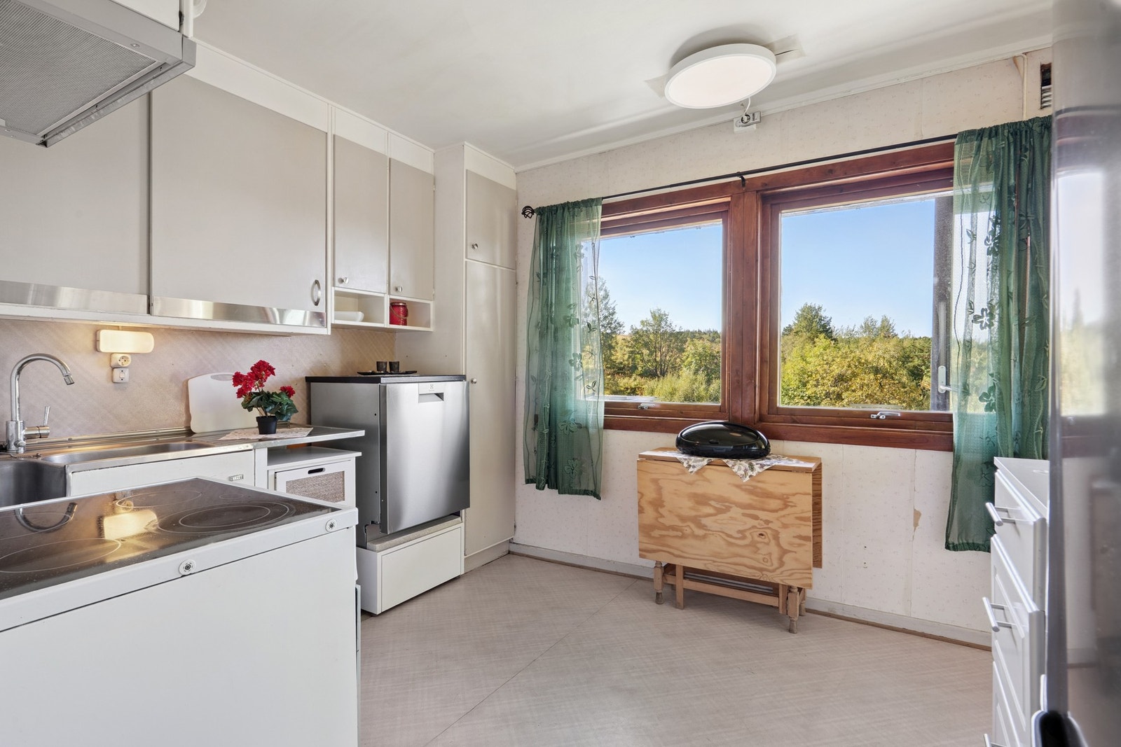 Kjøkkenet er innredet med malte fronter og benkebeslag av rustfritt stål Galleribilde