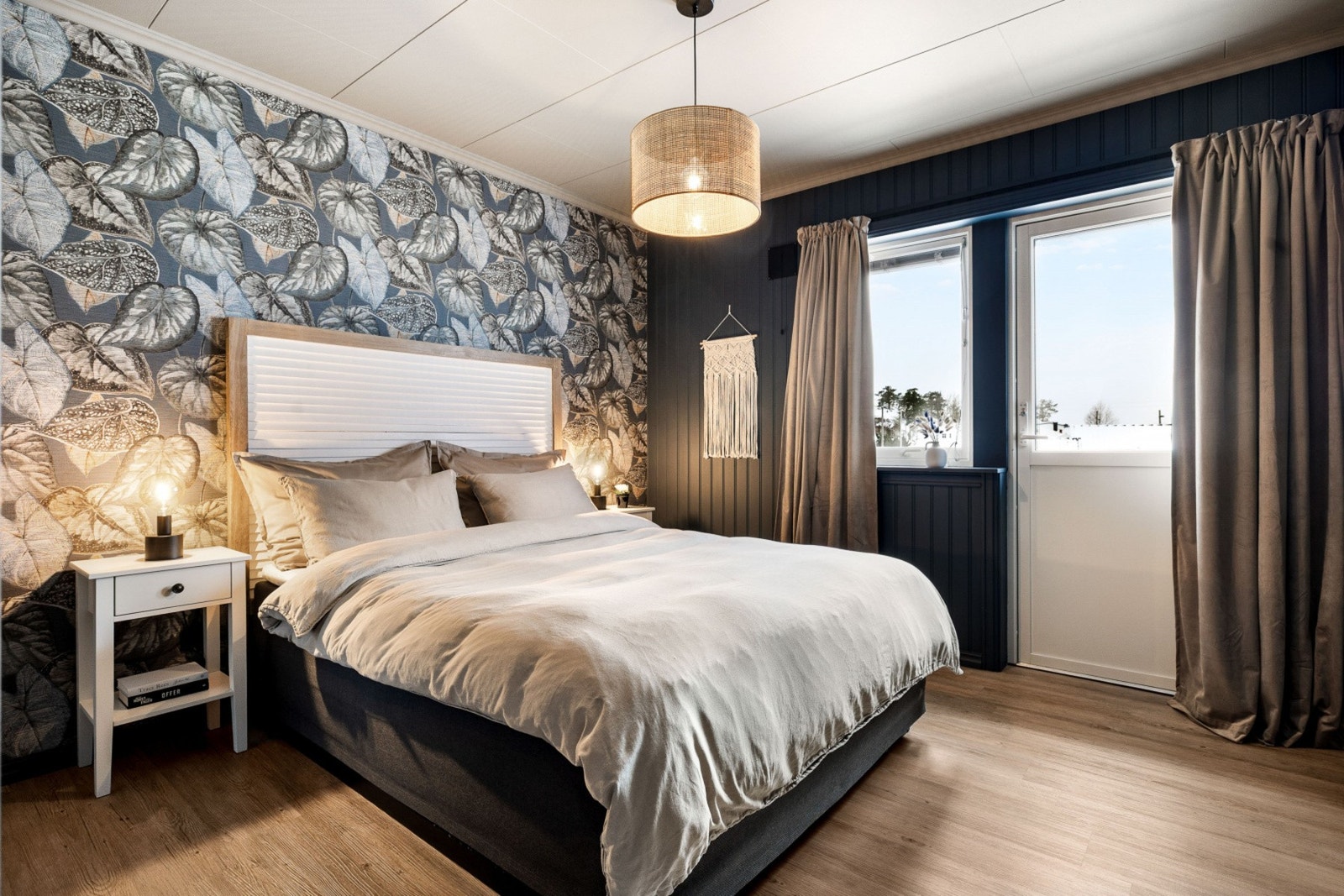 Soverommet har en moderne stil med tapet på veggen, store vinduer og god belysning. Galleribilde