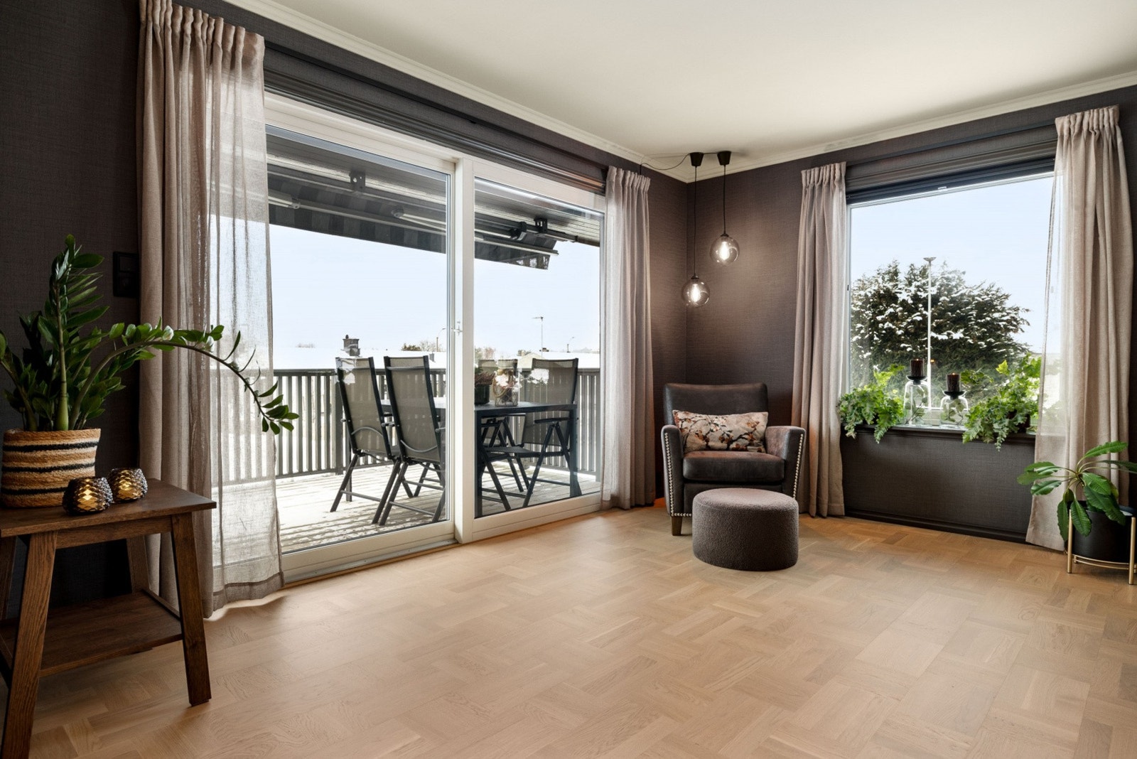 Stue med store vinduer og utgang til balkong, som gir mye naturlig lys og utsikt til omgivelsene. Galleribilde