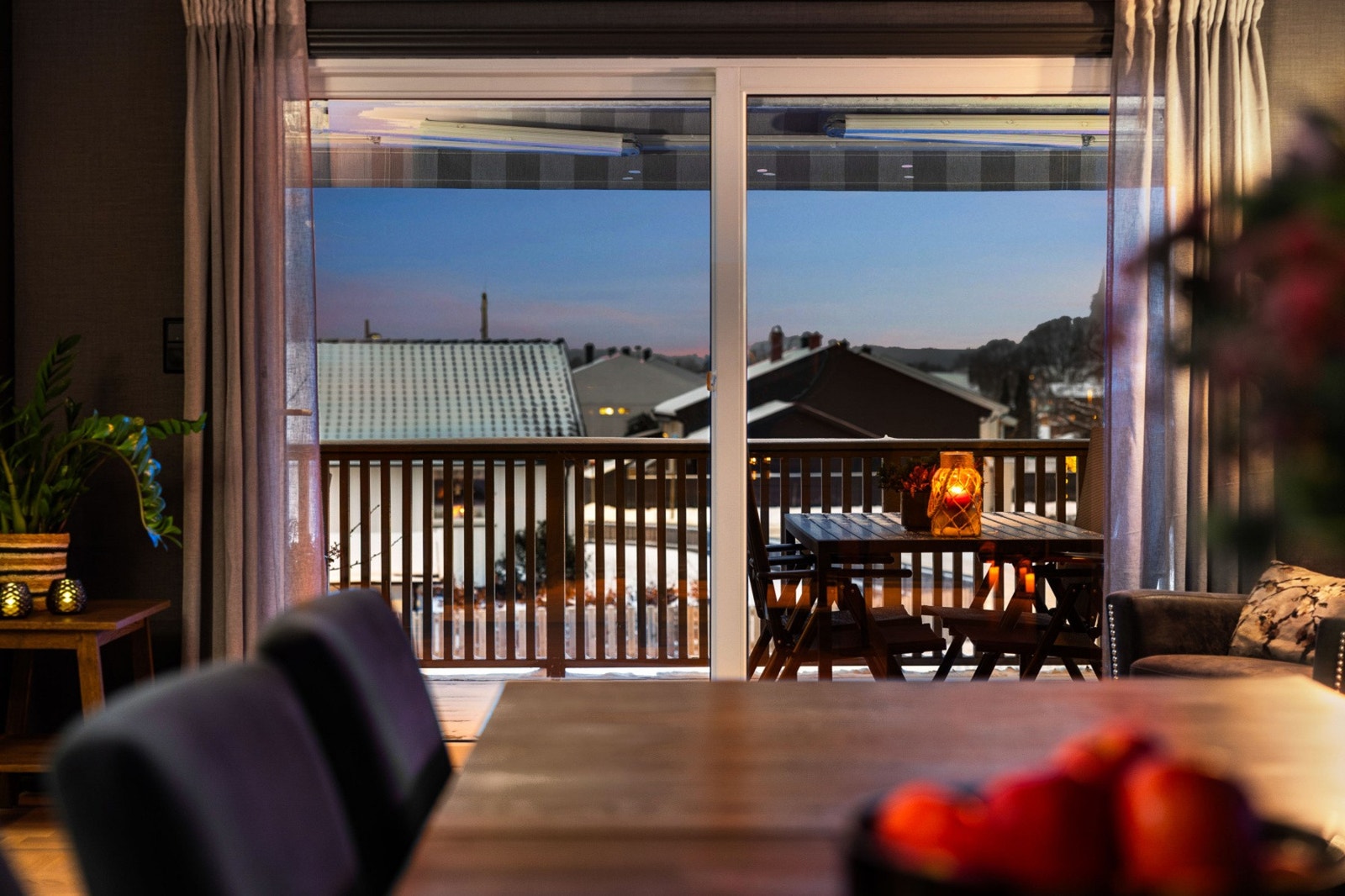 Store vinduer gir utsikt mot balkong og nærliggende hus. Galleribilde