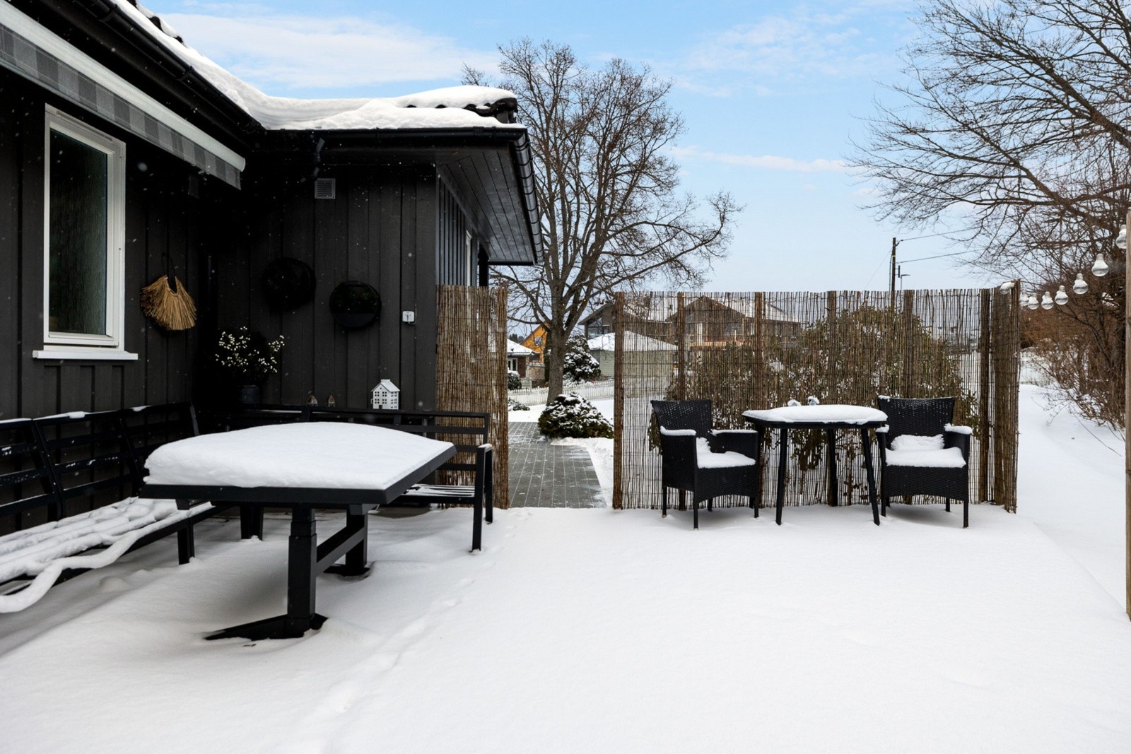 Uteområdet er nå vinterkledd med snø, og har sitteplasser på terrassen ved siden av huset. Koselige og lune uteplasser! Galleribilde