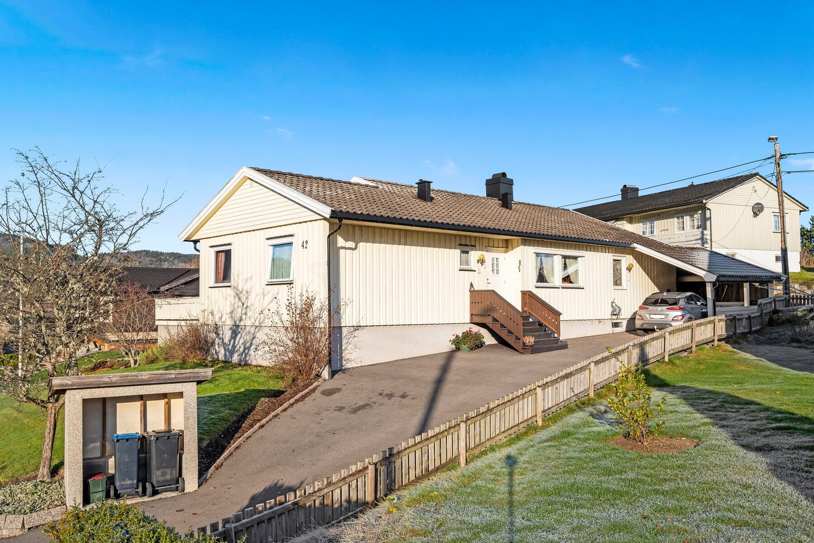 Boligen fremstår godt holdt av dagens eier. Asfaltert gårdsplass med carport og elbil-lader. Galleribilde