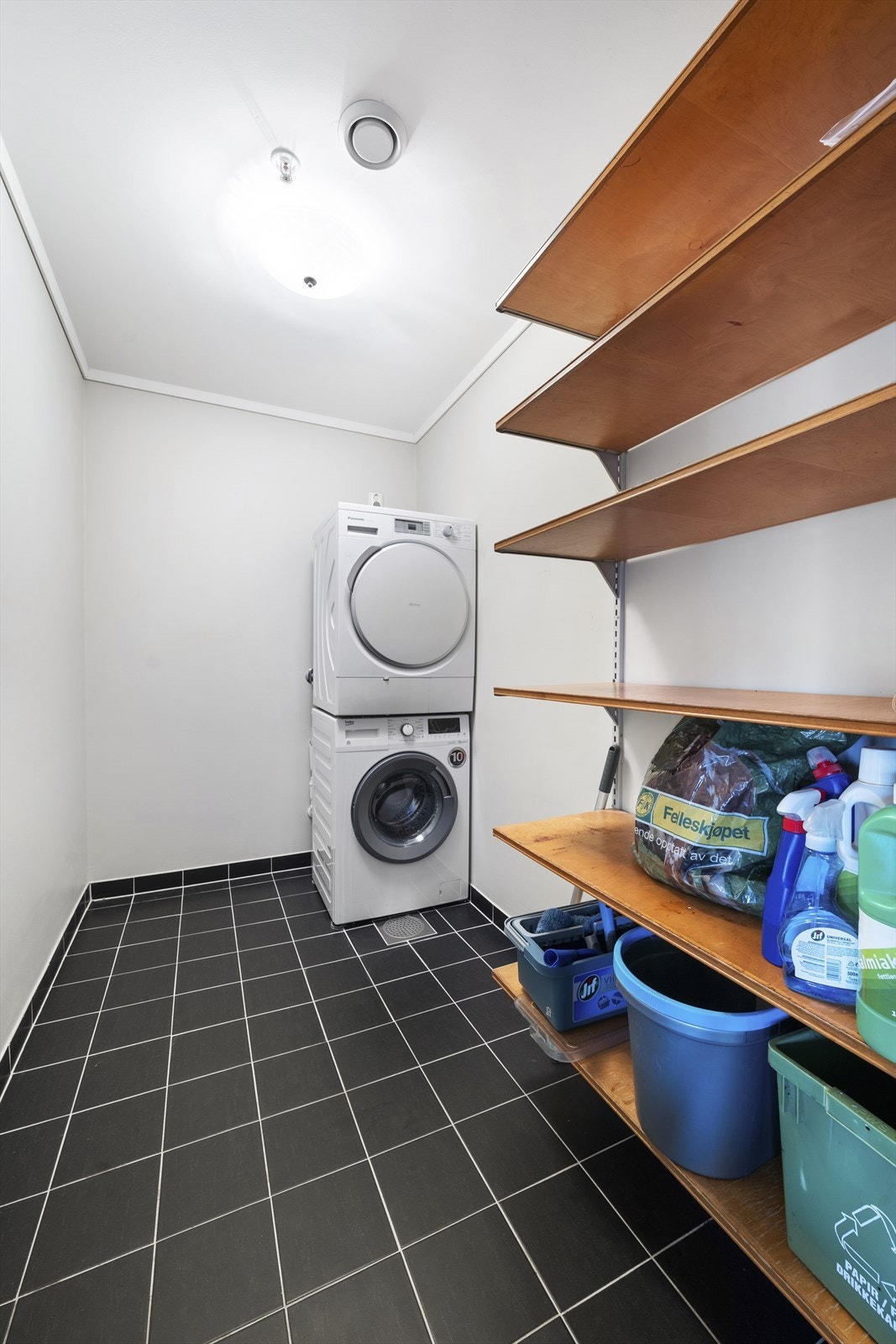 Vaskerom med plass til vaskemaskin og tørketrommel og annen oppbevaring Galleribilde