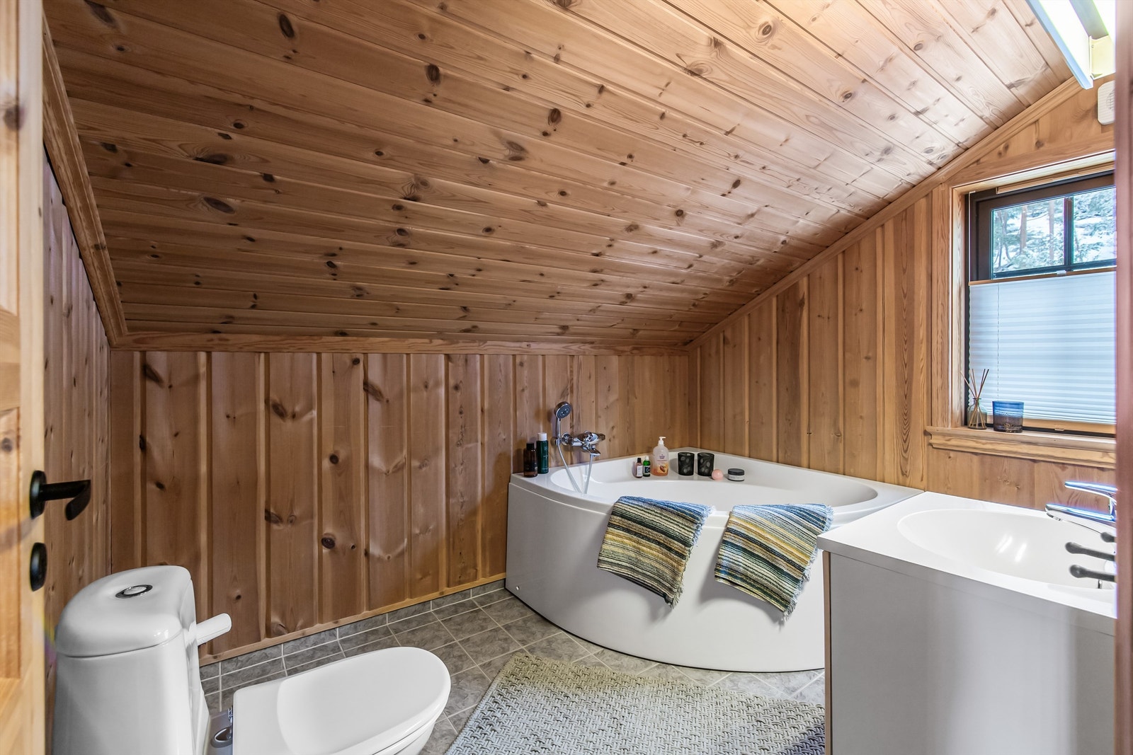 Bad 2 i 2. etasje er innredet med toalett, badekar og servant i innredning Galleribilde