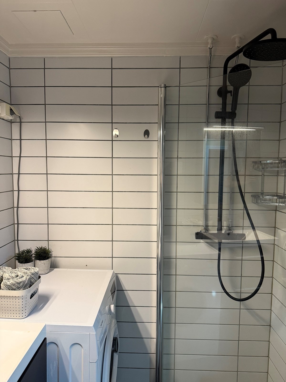 Badet er utstyrt med servant med underskap, speil med lys, dusjnisje med regndusj og toalett Galleribilde