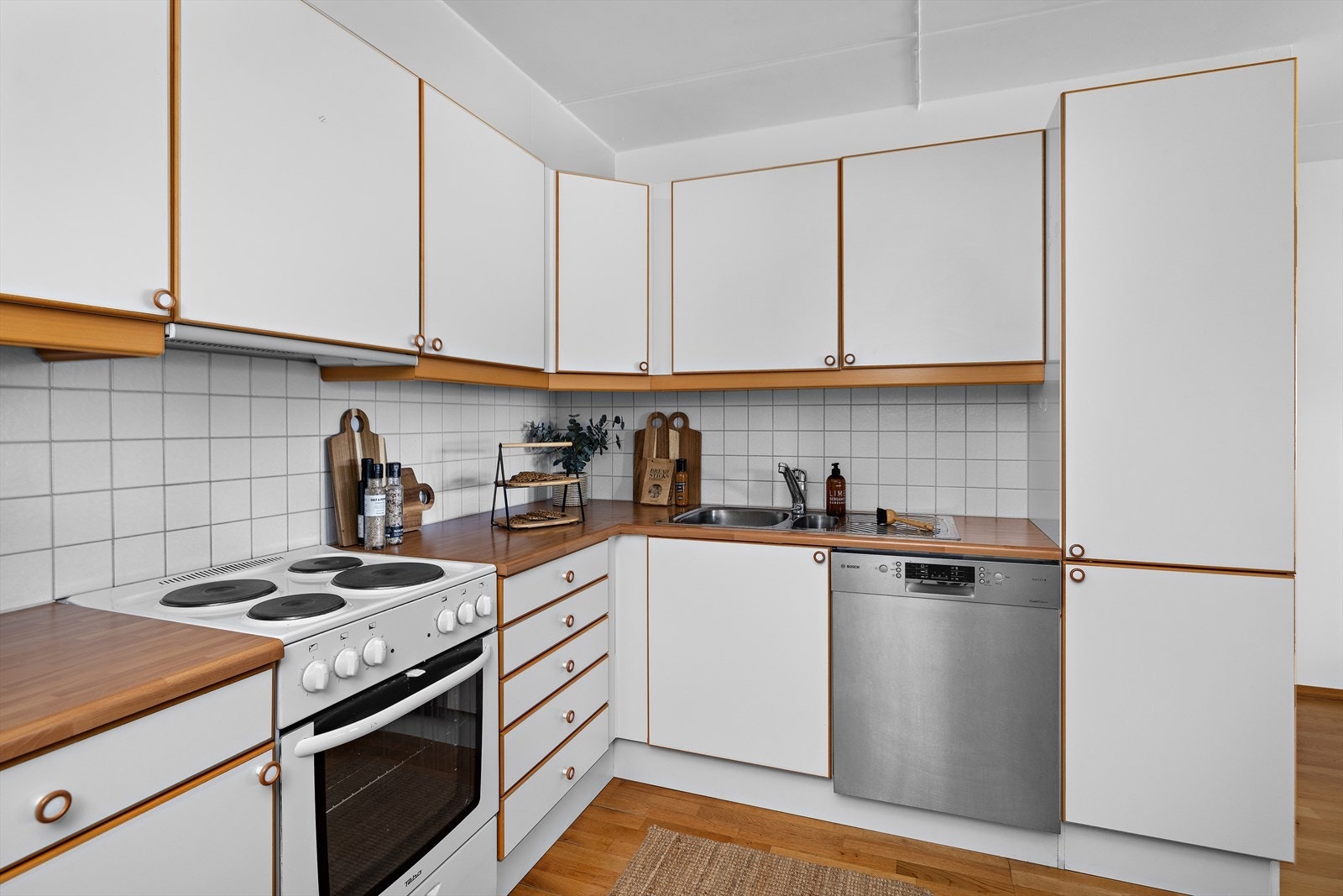 Kjøkkeninnredning i hvit utførelse med glatte fronter og eik kantlister. Galleribilde