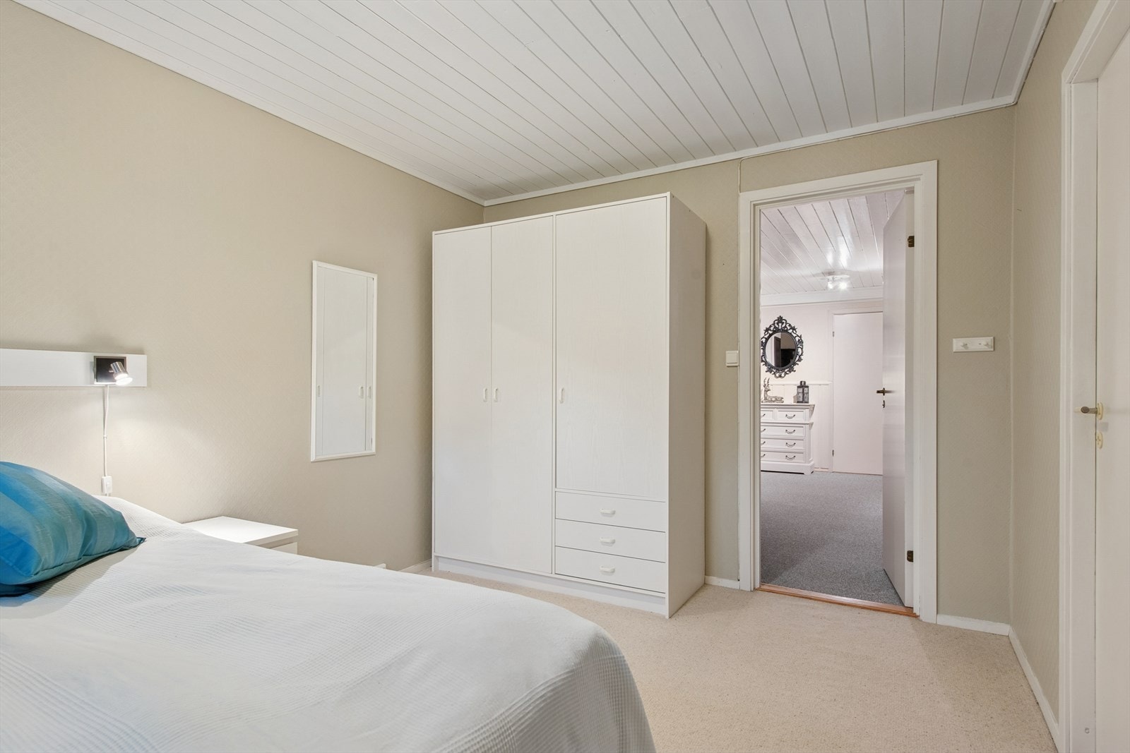 Lyst og romslig soverom med garderobeskap. Galleribilde