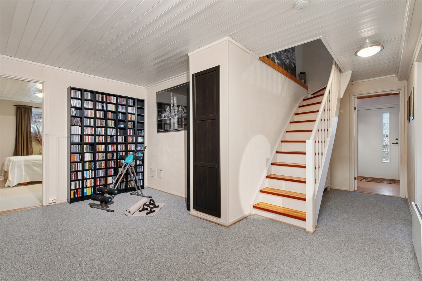 Malt tretrapp leder til underetasjen, mens lakkerte trappetrinn gir en solid følelse. Vegg-til-vegg teppe dekker gulvet, som gir en komfortabel overflate. Galleribilde