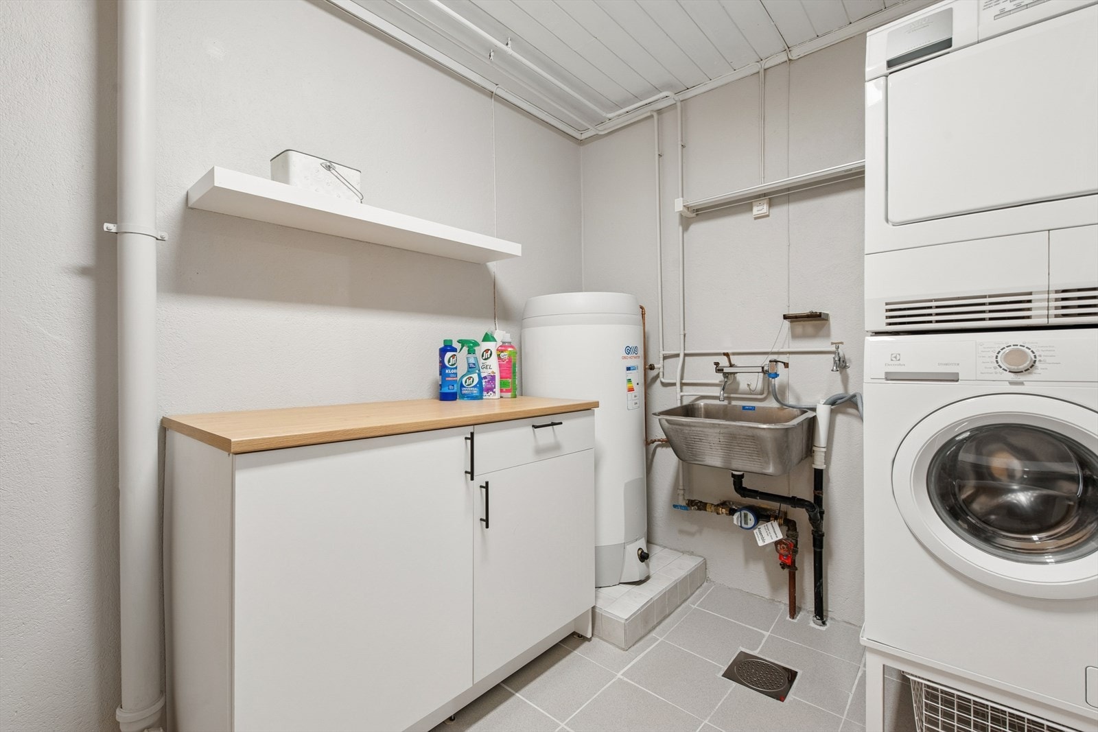 Vaskerommet er innredet med en rustfri utslagsvask og opplegg for vaskemaskin. Galleribilde