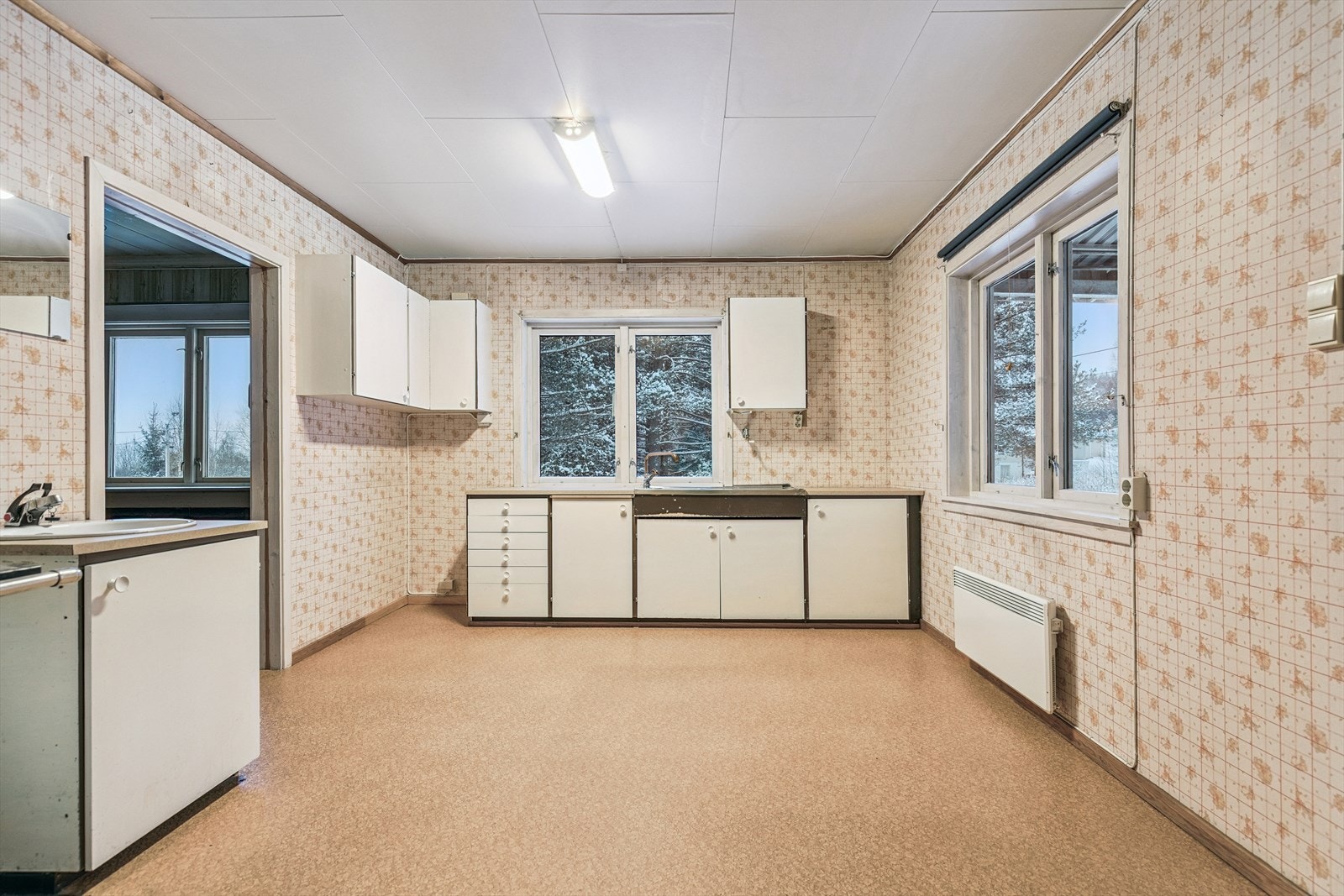 Kjøkkeninnredning med slette fronter, laminerte benkeplater og plass til frittstående hvitevarer. Galleribilde