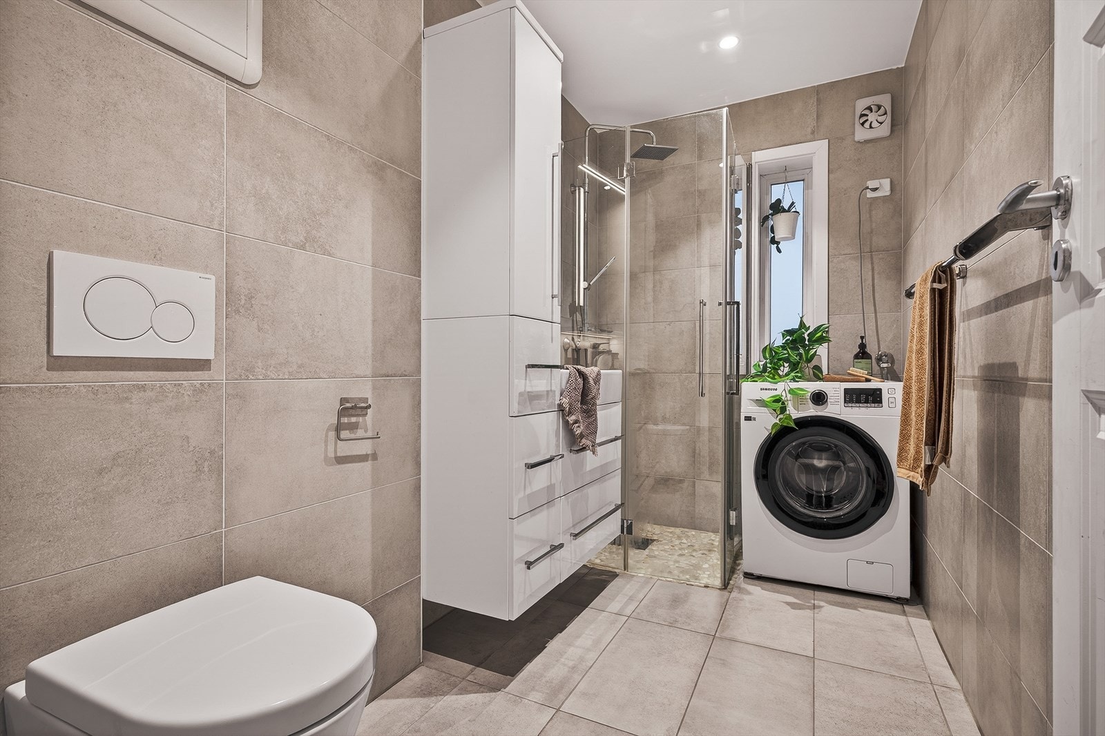 Flott bad med vegghengt toalett, innsvingbare dusjvegger og varme i gulv Galleribilde