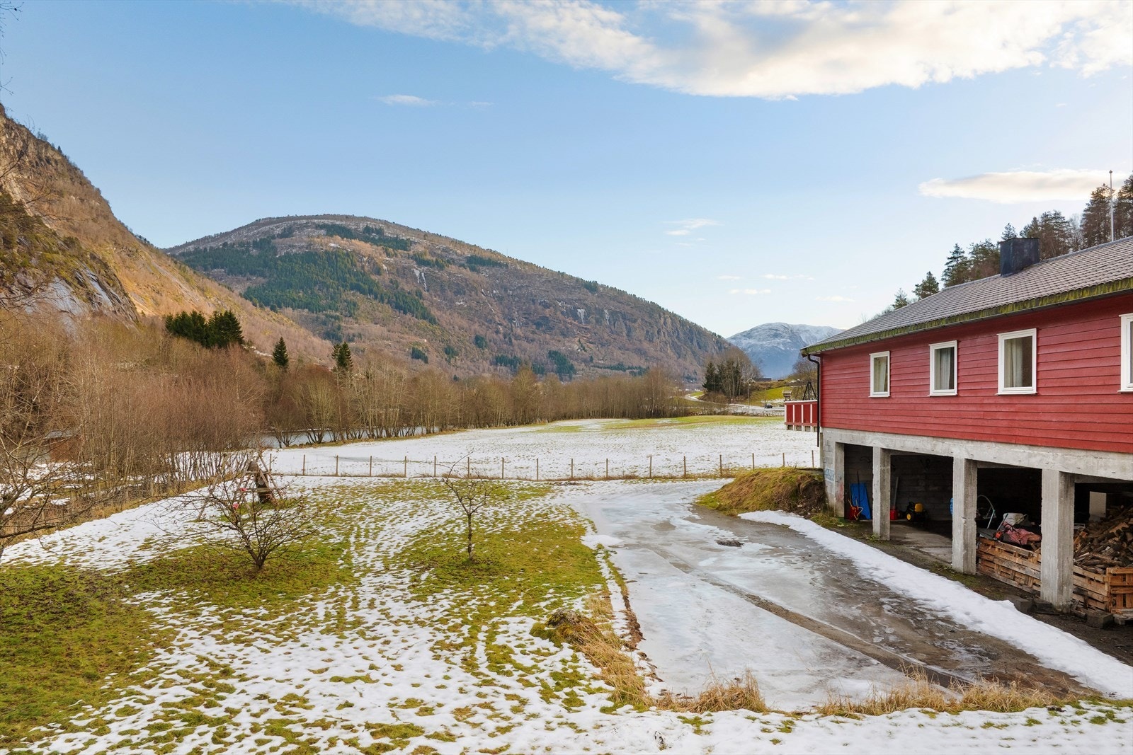 Det er opparbeida tun med god plass til parkering, hage med plen og planter, og eigedomen er for det meste inngjerda. Galleribilde