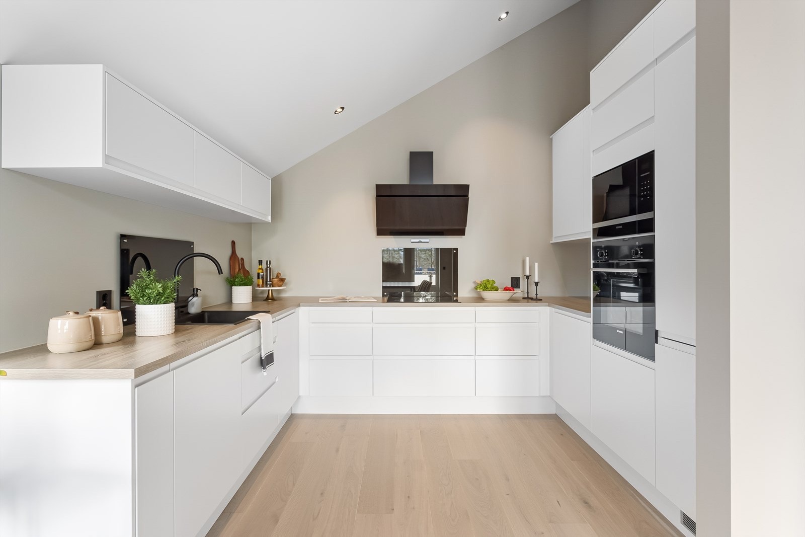 Det stilrene kjøkkenet har lys kjøkkeninnredning fra Norema og benkeplate i laminat. Galleribilde