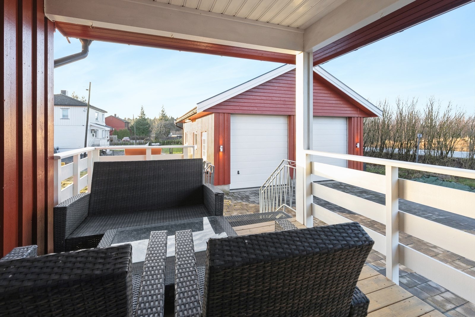 Den overbygde uteplassen ved inngangspartiet har utsikt mot den doble garasjen. Galleribilde