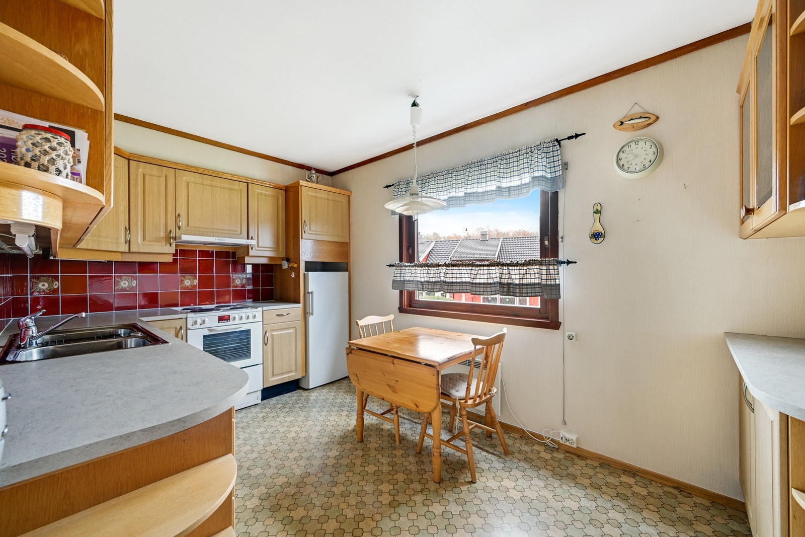 Vedlikeholdt kjøkken med plass til et hyggelig frokostbord Galleribilde