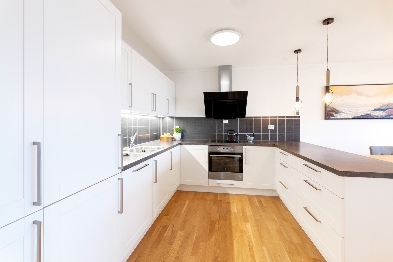 Kjøkken med hvite fronter og laminat benkeplate. Godt med skap og benkeplass. Galleribilde