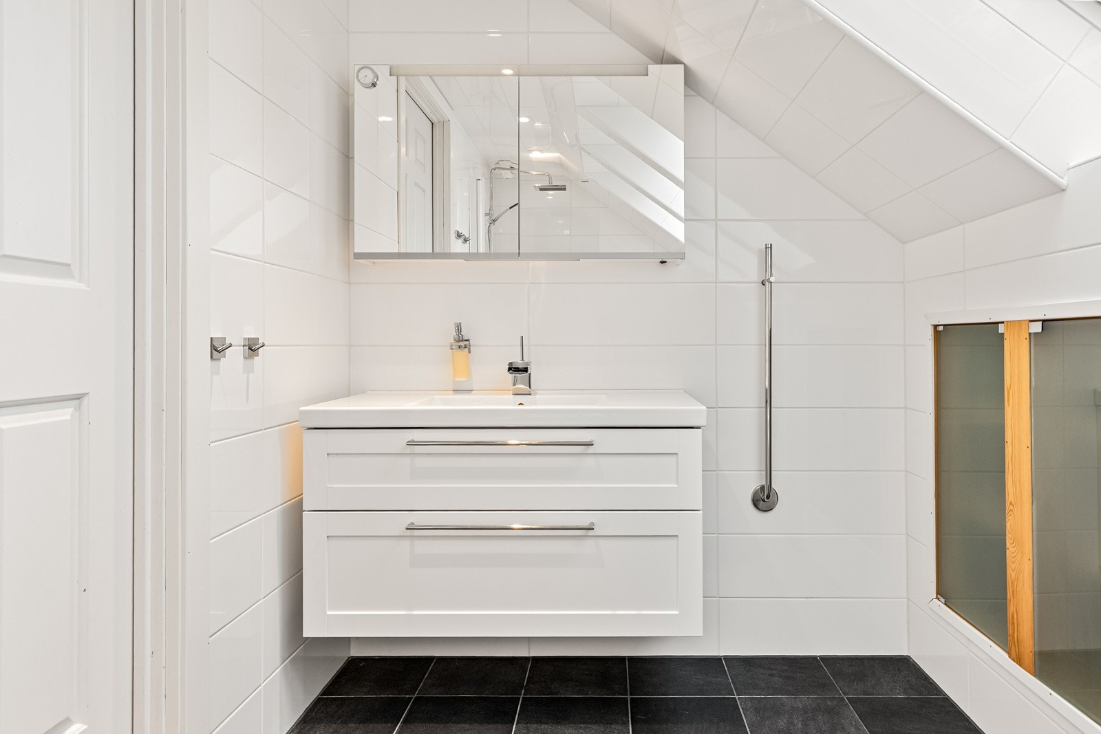 Baderomsinnredning med heldekkende servant og speilskap. Galleribilde