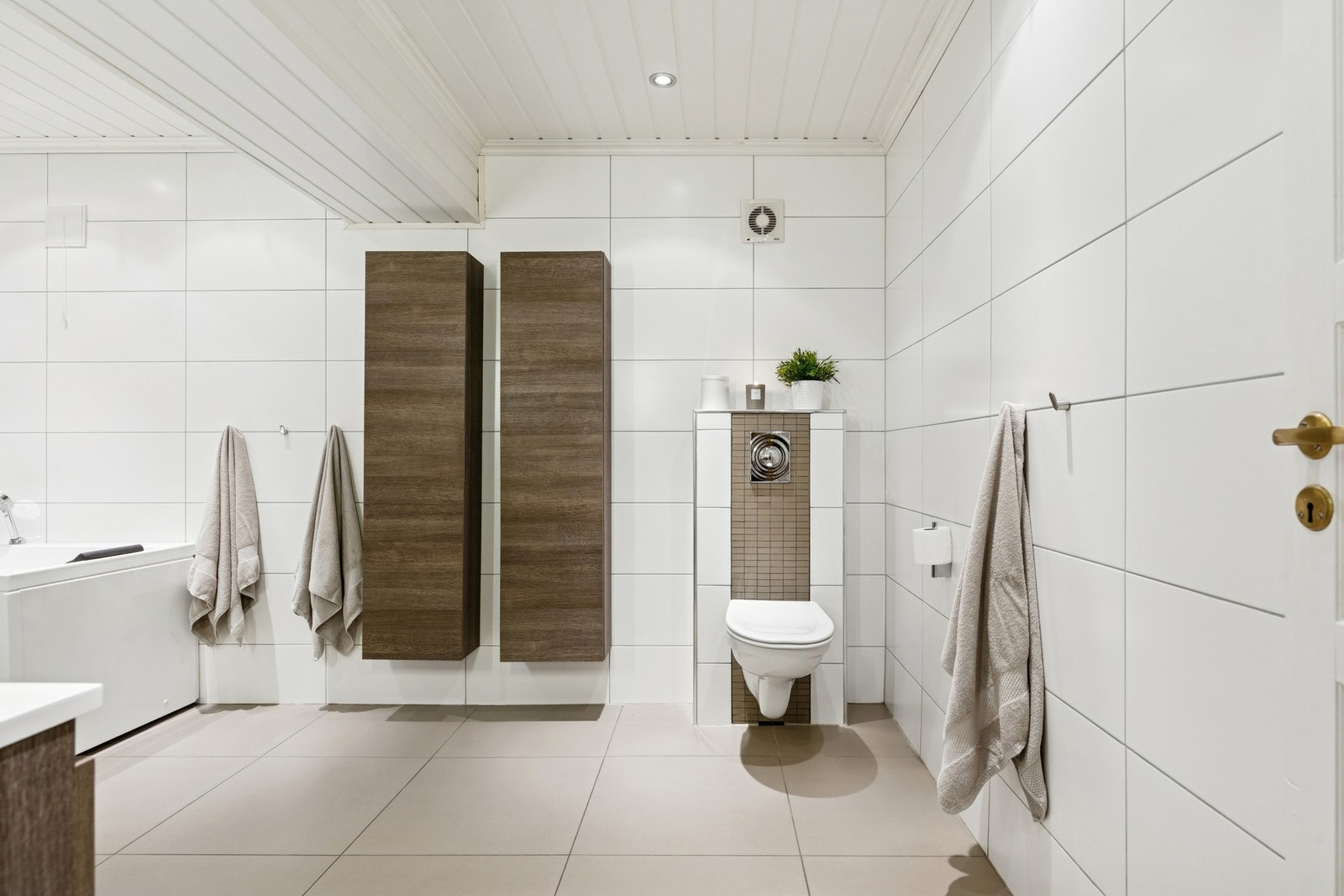 I underetasjen finner du et romslig baderom som kan by på flislagte vegger og gulv med gulvvarme, vegghengt servantinnredning med nedfelt servant, dusjnisje og gulvmontert badekar. Galleribilde