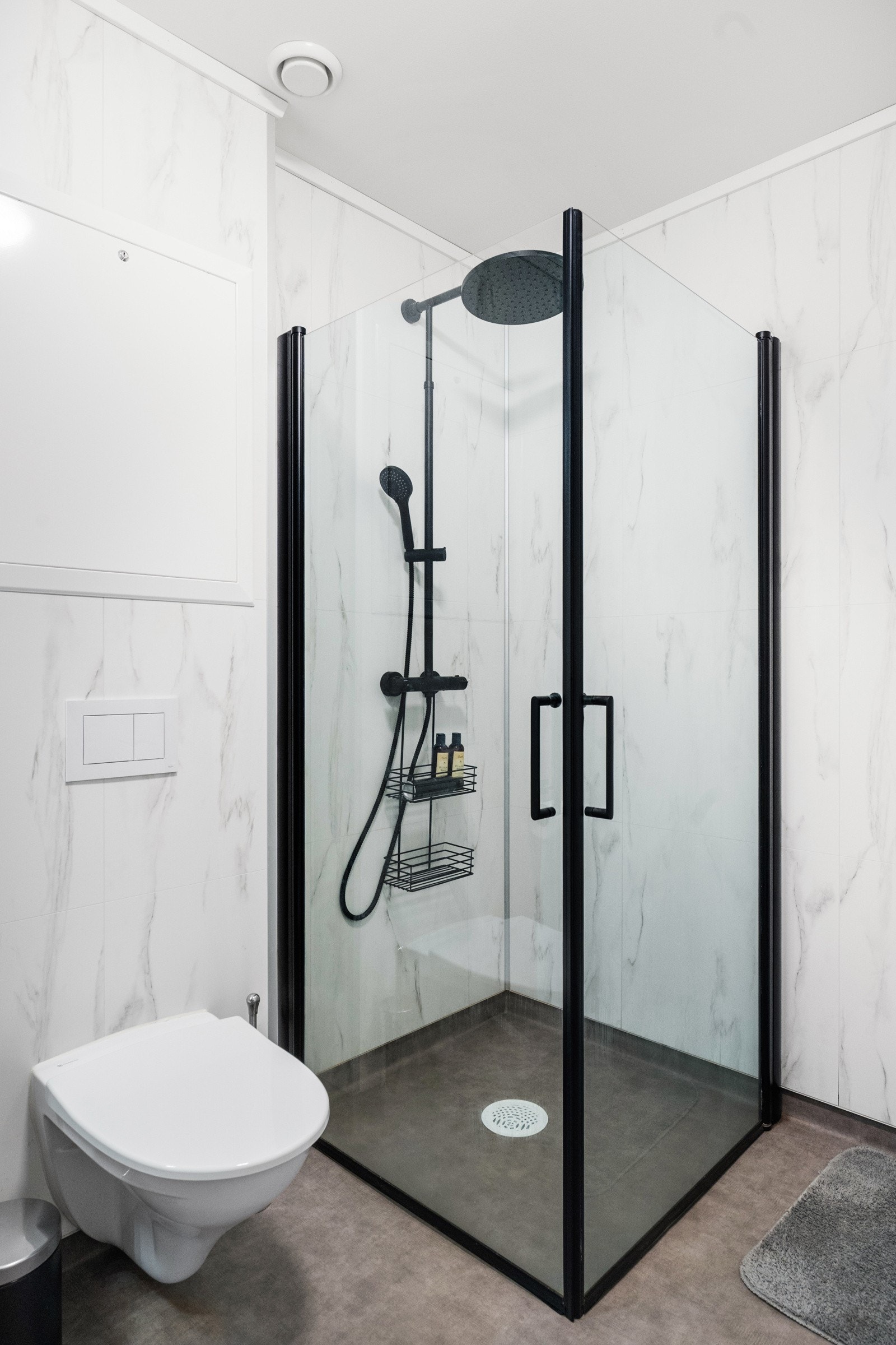 Her er det servant med underskap, speil med belysning, dusjvegger, veggmontert toalett samt opplegg for vaskemaskin. Galleribilde