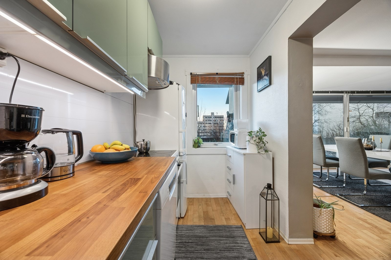 Kjøkken med glatte fronter, laminat benkeplate med nedfelt stålkum med to basseng, ettgreps kjøkkenkran. Galleribilde