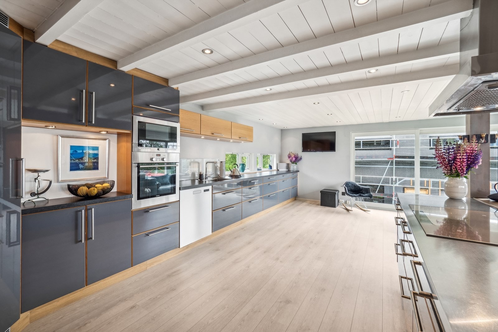 Pent kjøkken med glatte fronter og laminat benkeplate med oppvaskkum, samt downlights i himling. Galleribilde