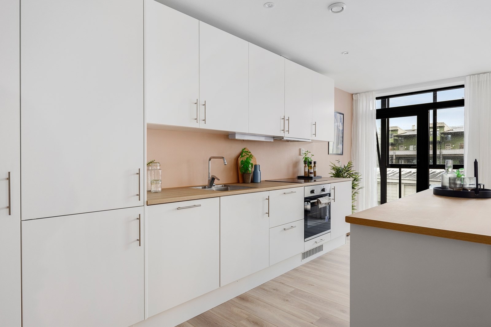 Kjøkkenet er godt utnyttet og har slette, lyse fronter og laminert benkeplate. Galleribilde