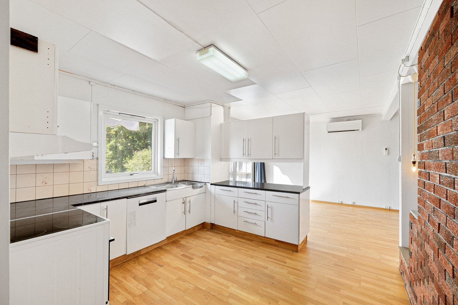 Lyst og romslig kjøkken med åpen løsning mot stuen. Her er det mulighet for å sette sitt eget preg gjennom modernisering og oppgradering. Galleribilde