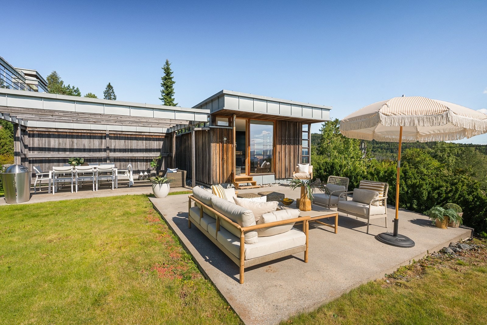 Tomten har store markterrasse, grøntområder og beplantning. Opparbeidet gangvei fra garasjen opp til boligen. Galleribilde