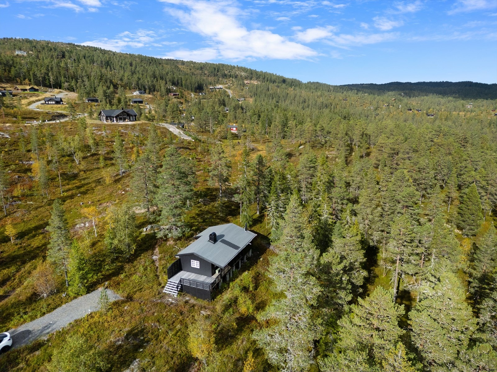 Hytta ligger fint til i terrenget, på ''tuppen'' av et flatere parti, med skrånende terreng nedenfor. Galleribilde