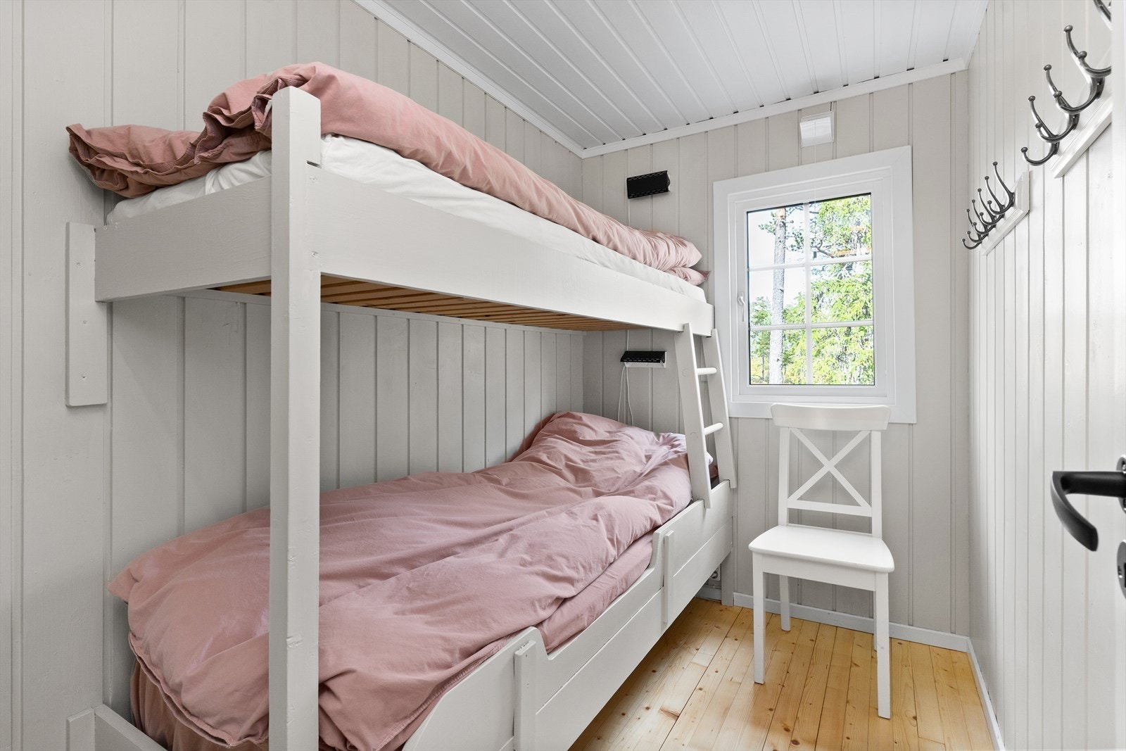 Soverom 3 er utstyrt med en tradisjonell køyeseng-løsning. På veggen har man godt med knaggrekker. Galleribilde