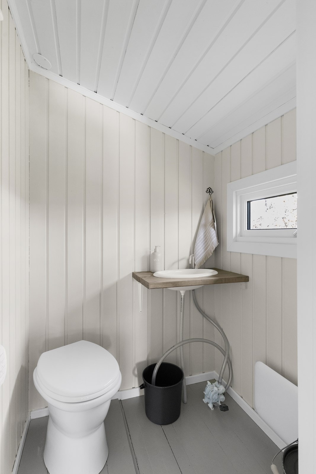 Enkelt toalettrom, med en enkel pumpevask med vann fra bøtte, og med avløp ut. Toalettløsningen er en tradisjonell ''snurredo'' med ulike kamre for kompostering. Galleribilde