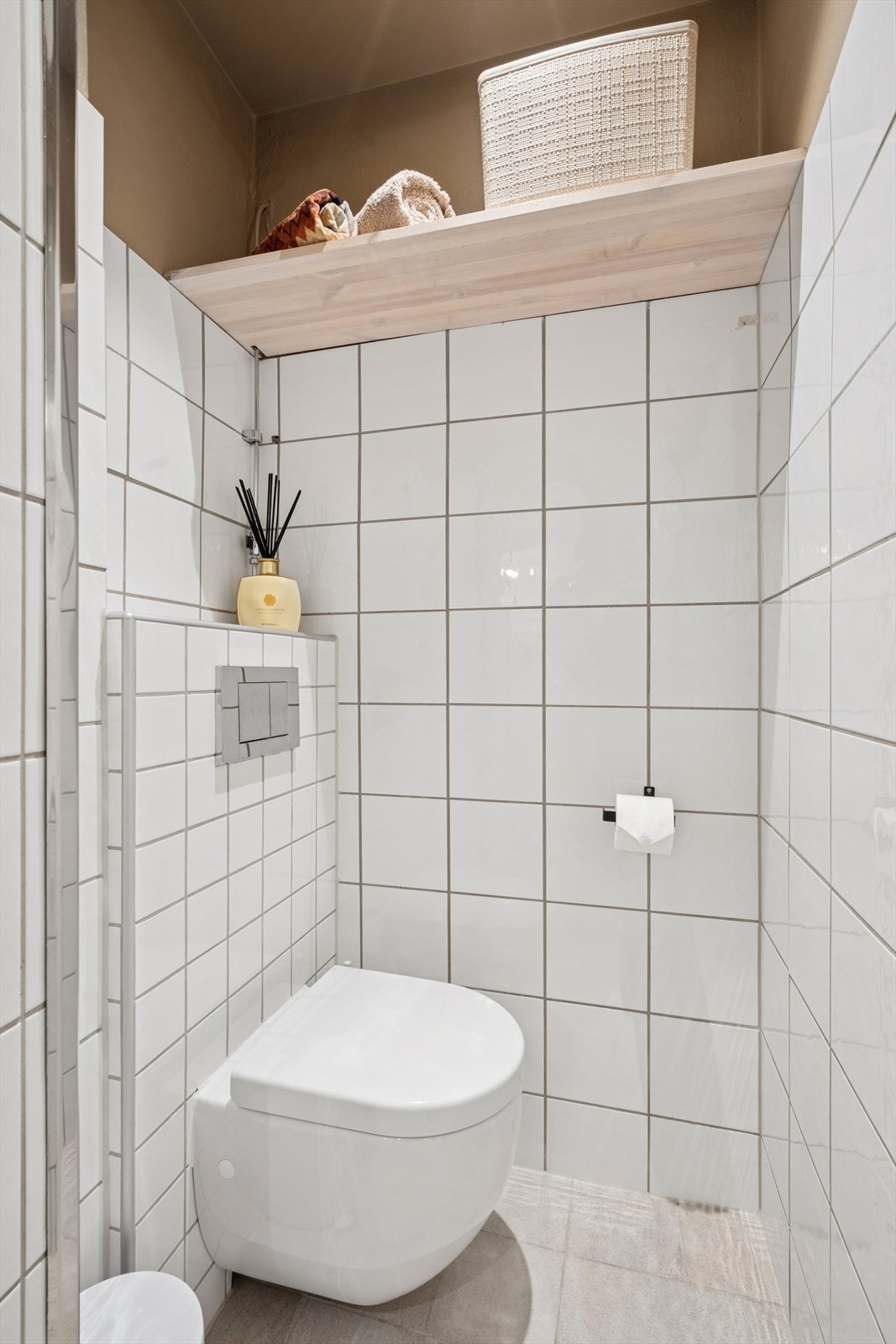 Rommet er innredet med vegghengt toalett med innebygget sisterne, dusjhjørne med glassvegger, et servantskap og et praktisk speilskap. Galleribilde