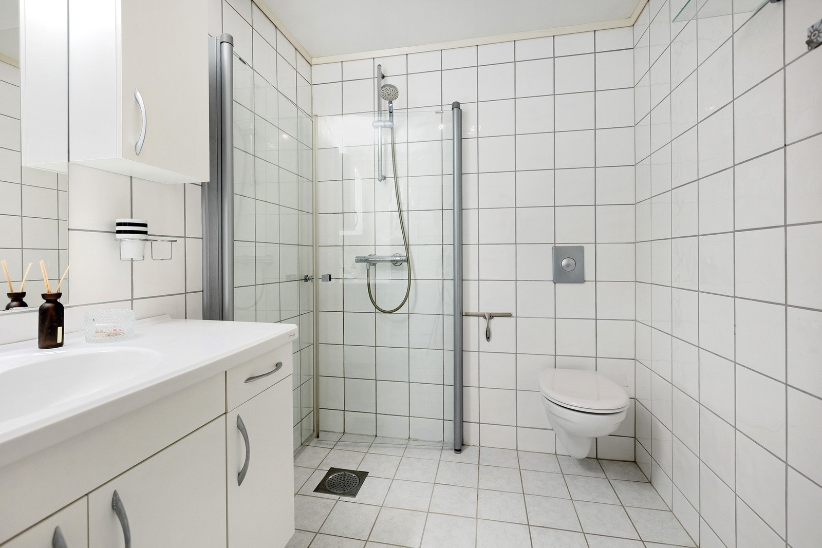 Dusjhjørne med innfellbare dører og vegghengt toalett . Galleribilde