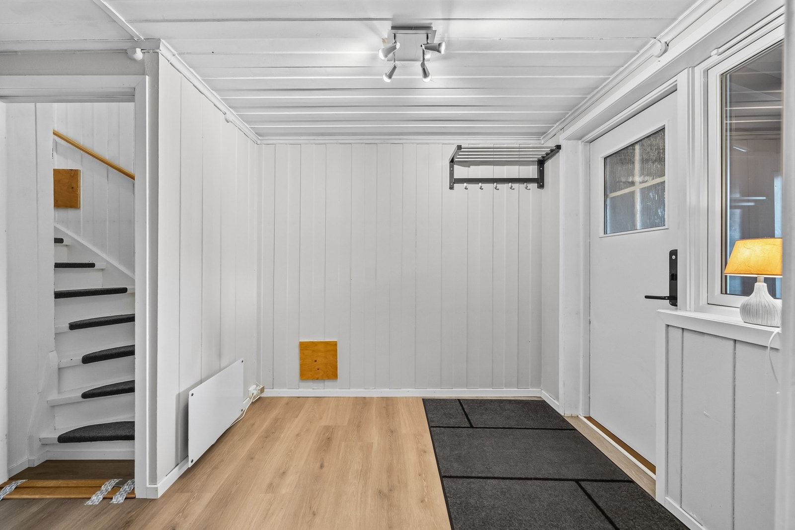 Romslig entre med lysmalt panel på veggflater og laminat på gulv. Rommet ble tilbygd i tilknytning til seksjonering rundt 1982, men er ikke formelt godkjent i kommunen. Tilbygget har omfattende råteskader og fuktproblematikk. Galleribilde