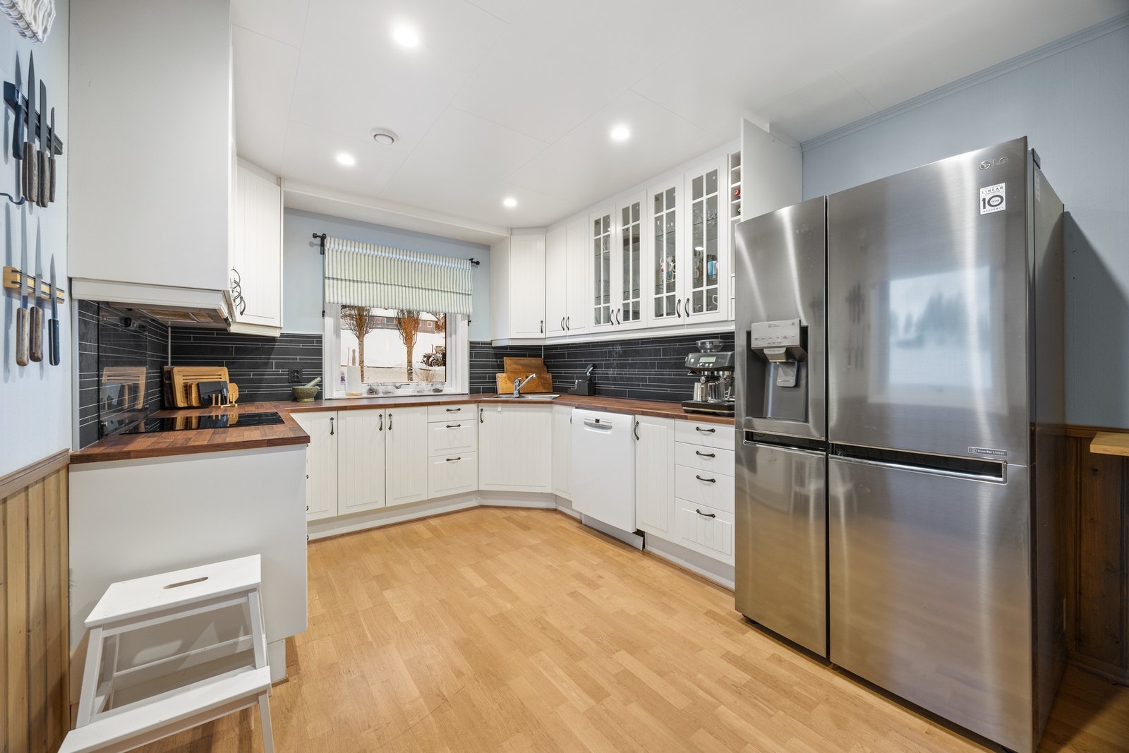 Kjøkkeninnredning med platetopp og stekeovn, samt avsatt plass for kjøleskap og oppvaskmaskin Galleribilde