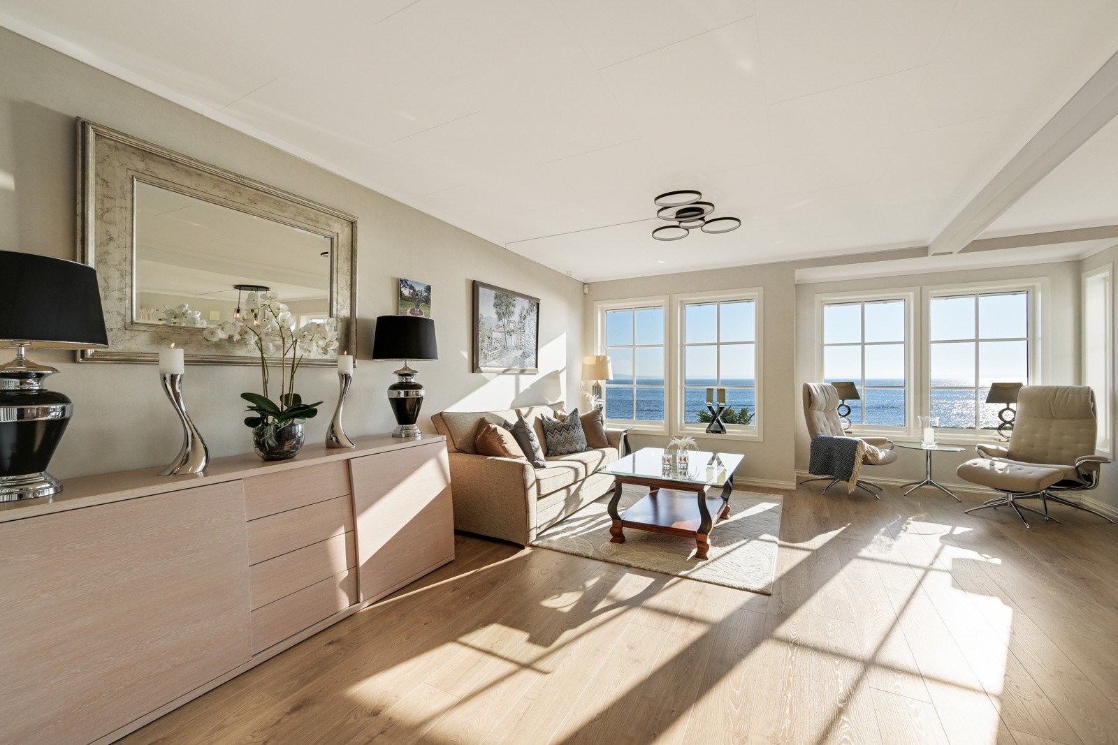 Lys vinkelstue med store vindusflater mot fjorden Galleribilde