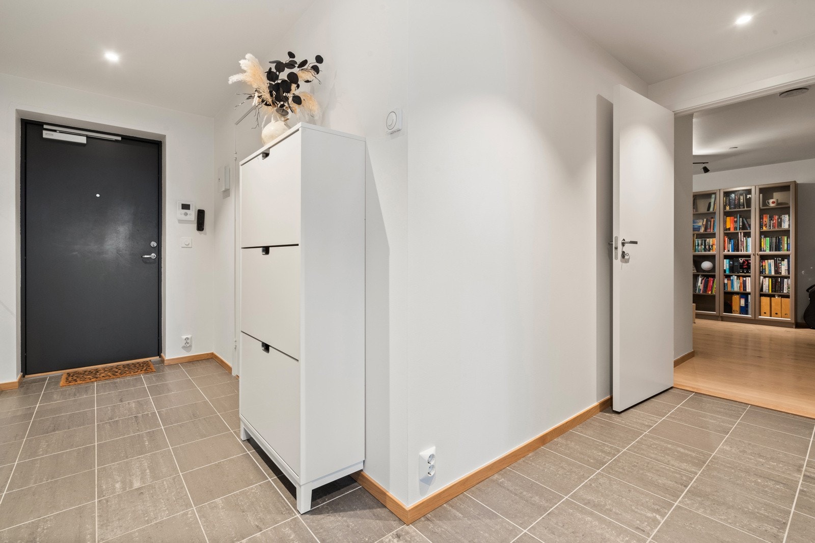 Leiligheten har en innbydende entré med plass til å henge fra seg yttertøy i garderobe og sko i skoskap. Galleribilde