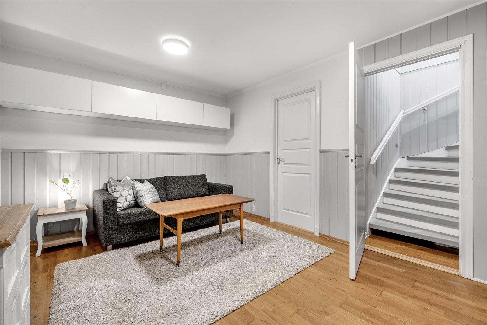 Fra kjellerstuen fører en malt tretrapp deg opp til boligens hovedetasje. Galleribilde