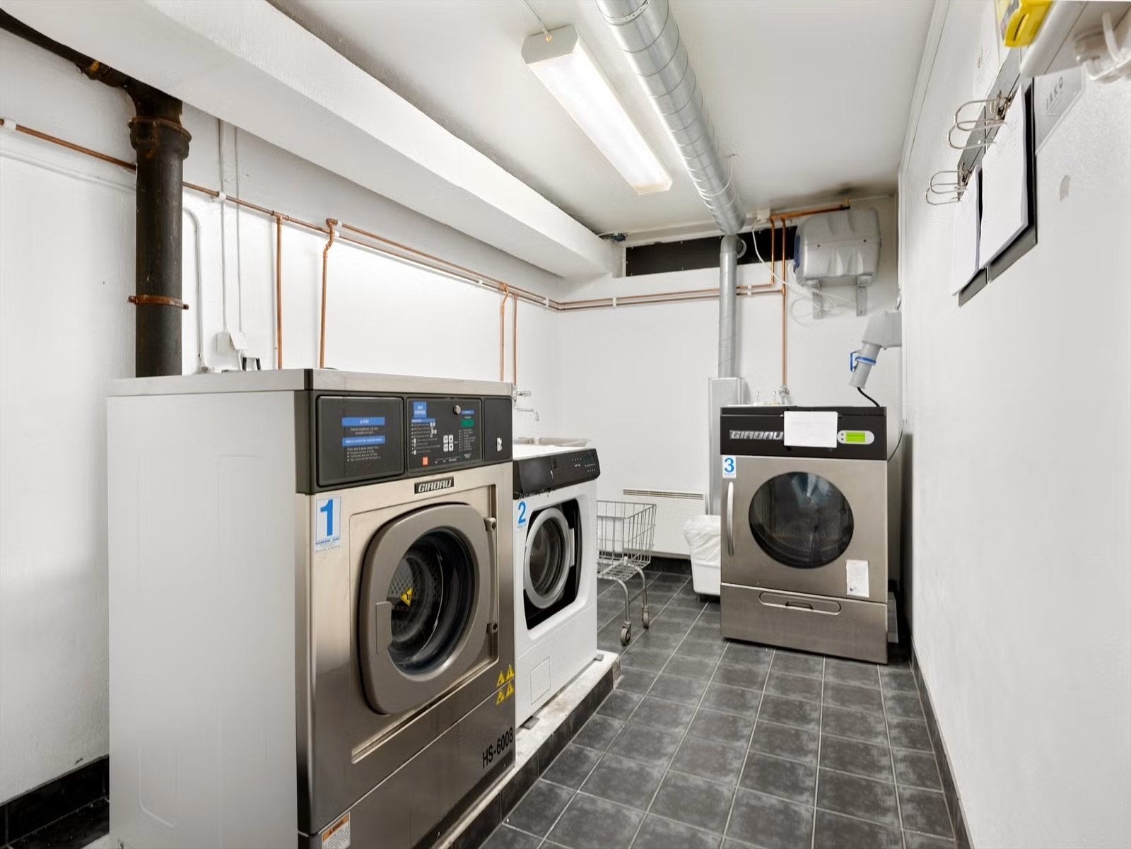 Felles vaskerom med to vaskemaskiner og en tørketrommel (industri). Galleribilde