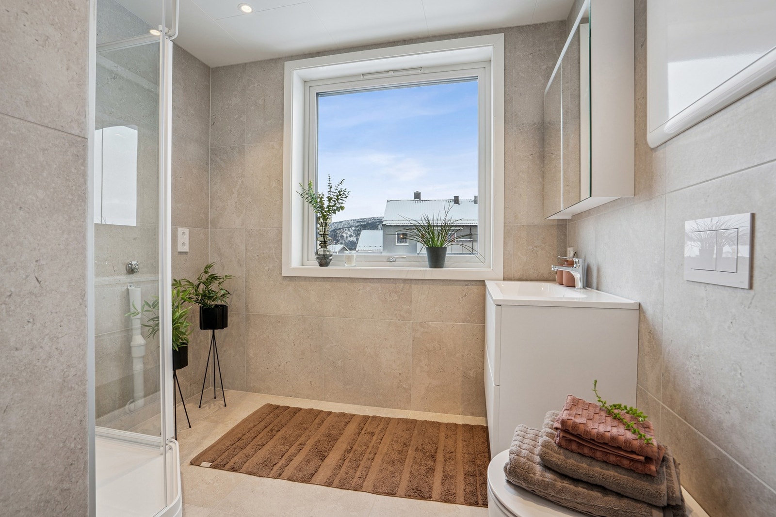 Badet er lyst og romslig med store fliser som gir et moderne uttrykk. Galleribilde