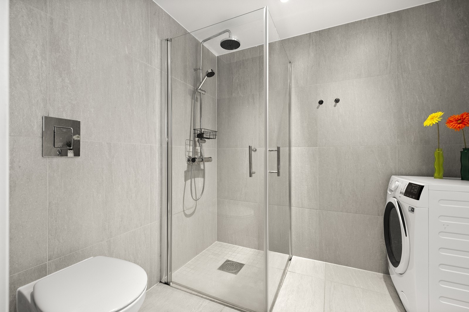 Bad med dusjløsning i glass og veggmontert toalett. Galleribilde