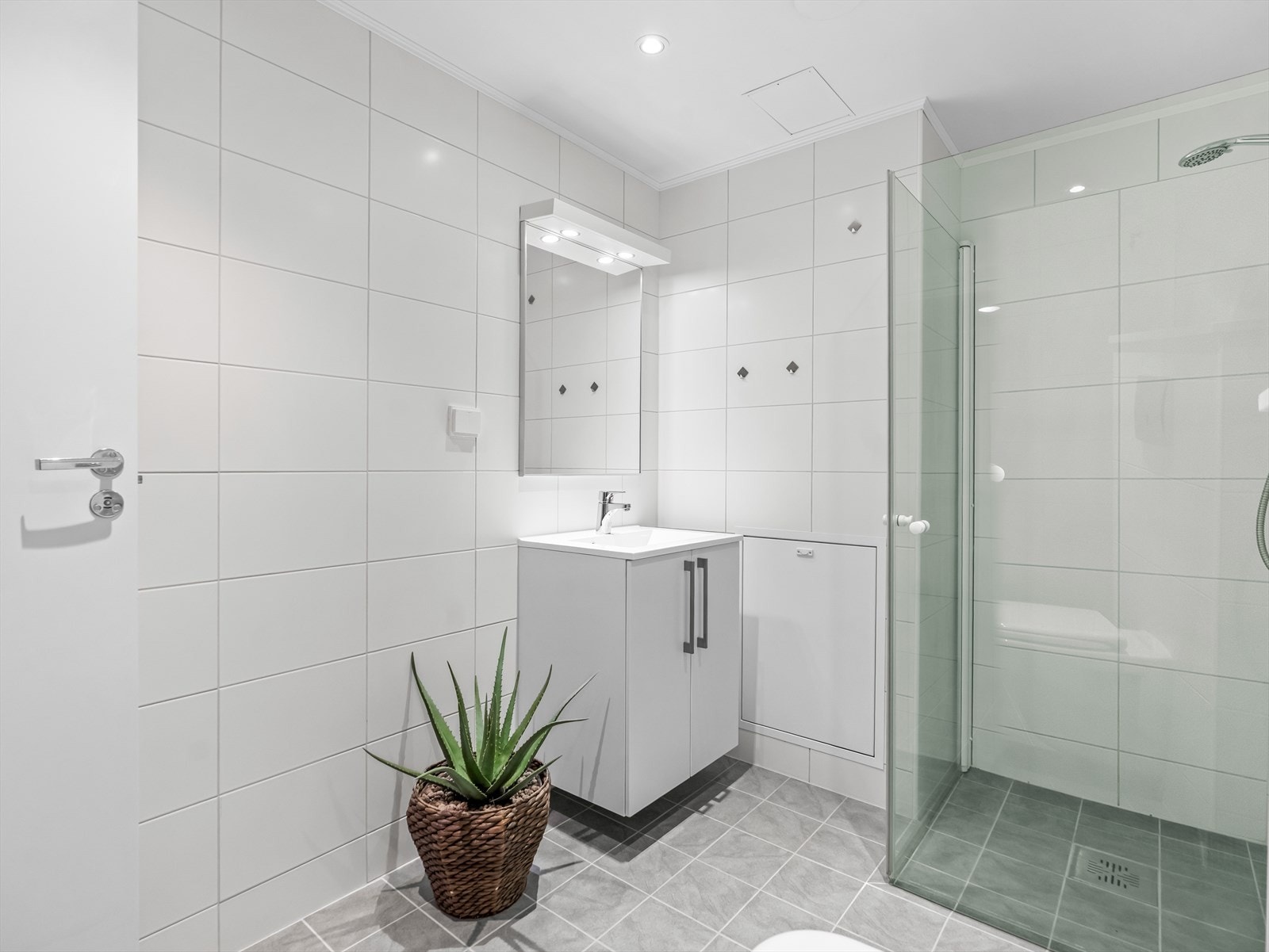 Innredningen består av skap med glatte fronter, servant, veggfestet klosett, dusj på gulv og opplegg for vaskemaskin. Galleribilde