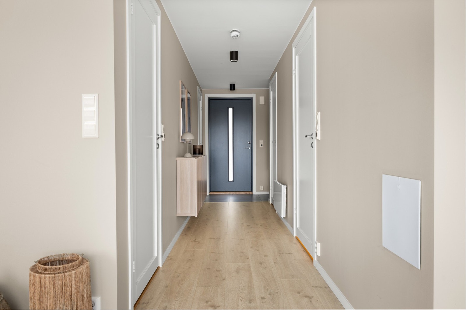 Vel inne er det en pen entré med lysmalte vegger, downlights i himlingen og grå fliser på gulv med gulvvarme Galleribilde