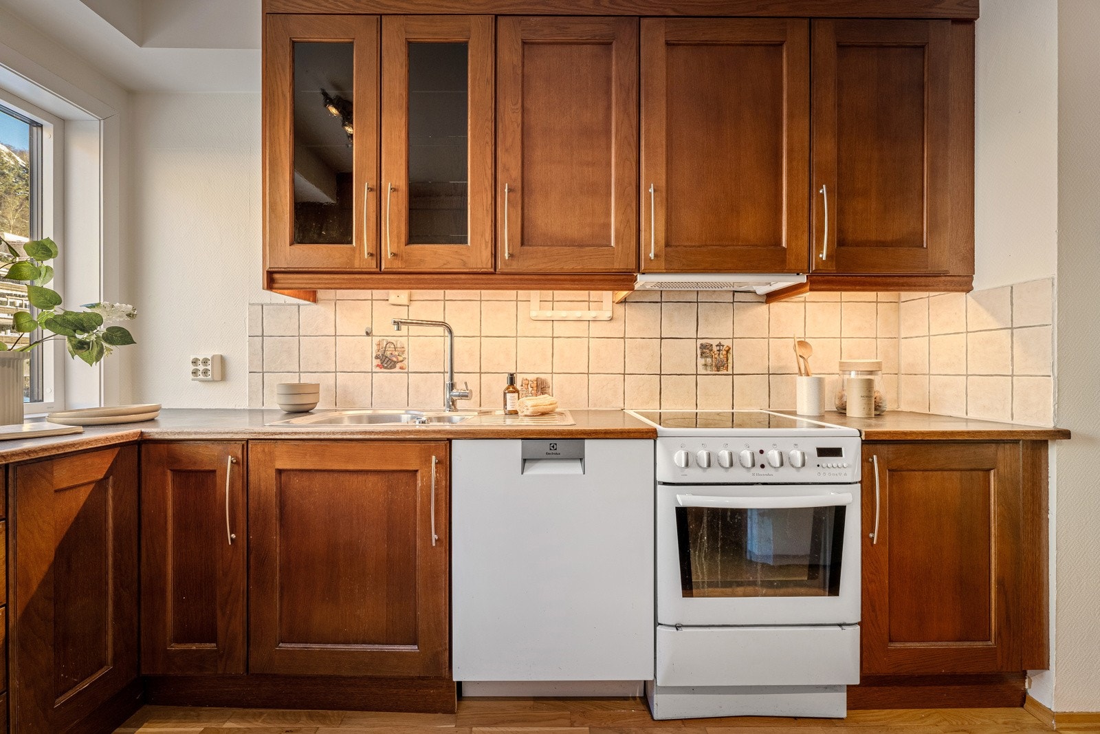 Kjøkkenet har godt med skap og benkeplass Galleribilde